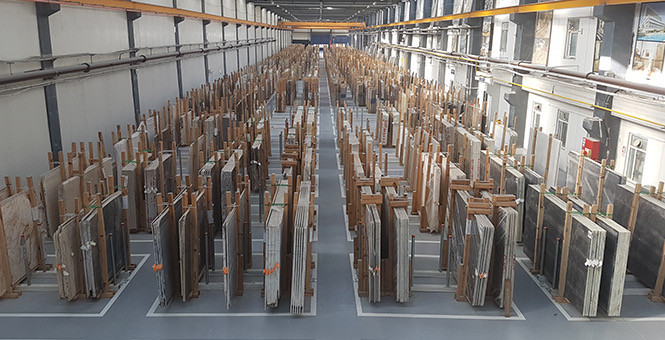Rows of marble and natural stone slabs stored in the Marbella warehouse