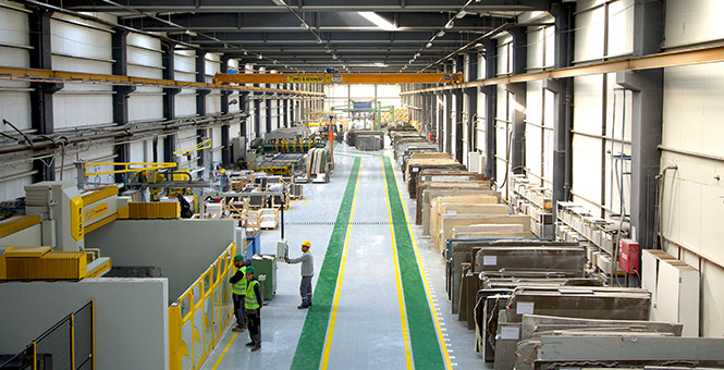 Marbella technicians reviewing cut stone slabs on the production floor